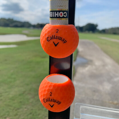 Orange pair of Callaway Cigar Balls with Cohiba Connecticut attached to golf cart