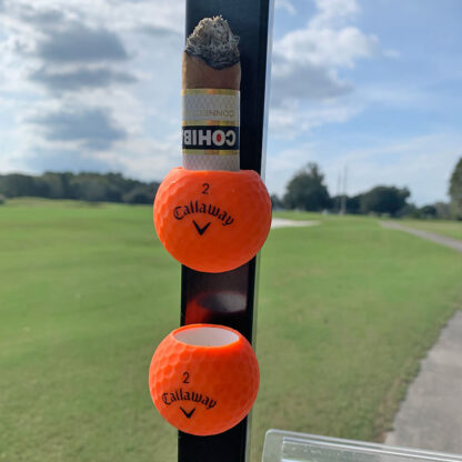 Orange pair of Callaway Cigar Balls attached to a golf cart