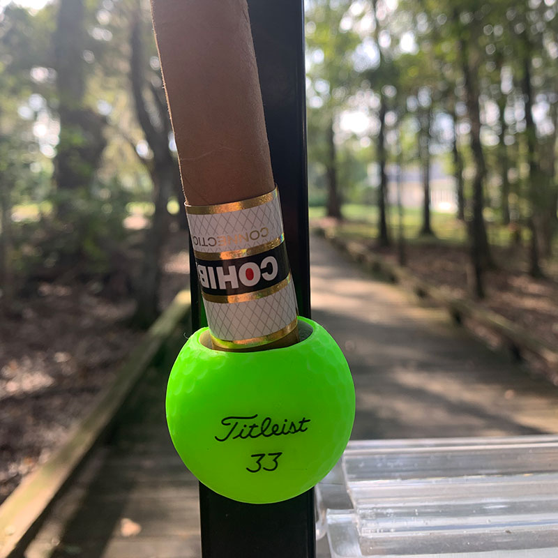 Green Callaway Cigar Ball holding a Cohiba Connecticut attached to a cart.